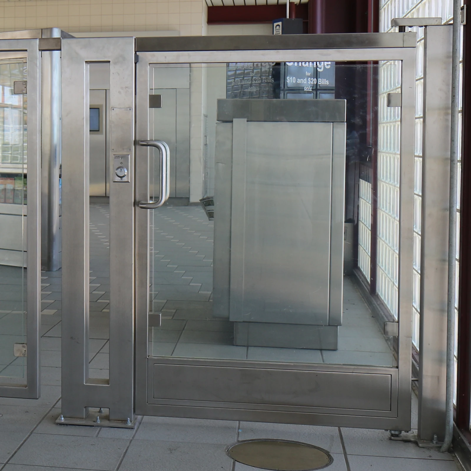 Tall clear-panel swing gate with a stainless steel frame and mounting posts